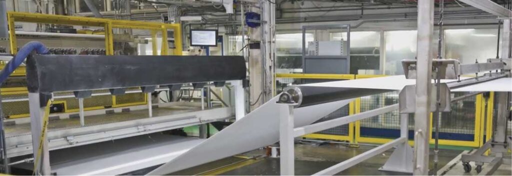 Nonwoven material moving through a controlled production process.