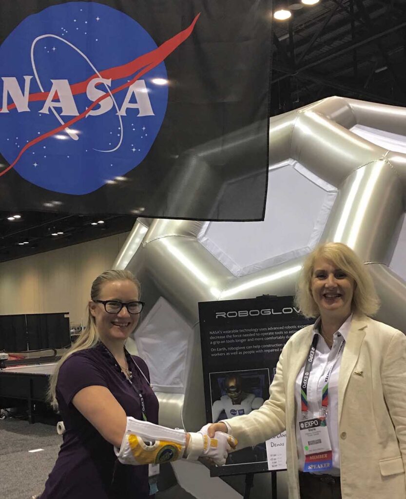 The author taking the opportunity to shake hands with NASA’s soft robot glove at AT Expo.