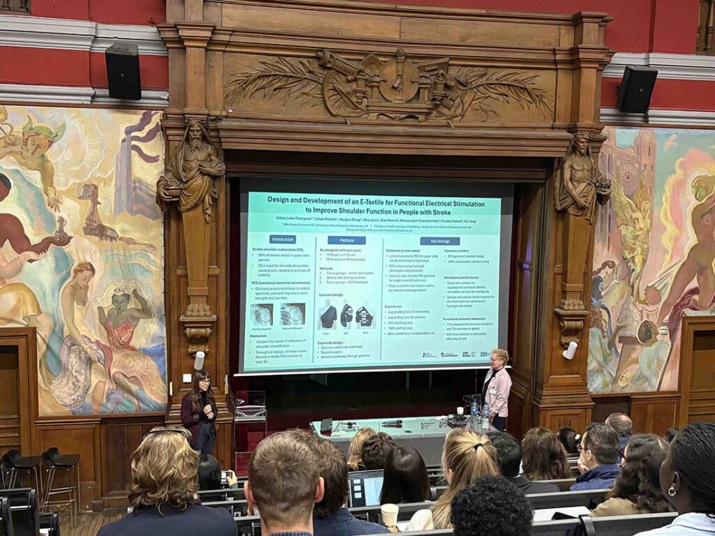 Gillian Lake-Thompson (left), E-textile Innovation Lab, University of Southampton, presenting her paper on “Design and development of an E-textile for a functional electrical stimulation to improve shoulder function in people with stroke” during E-textiles 2025 held in Lille, France. Photo courtesy of Marie O’Mahony